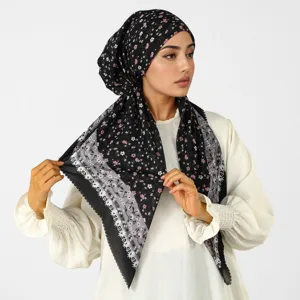Modella con foulard nero a fiori rosa e bordo decorativo grigio con effetto pizzo