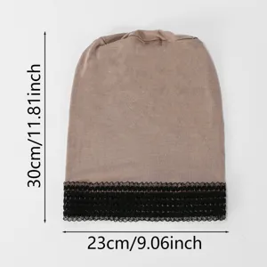 Copricapo in maglia color tortora steso in piano, bordo in pizzo nero e misure indicate: 30 × 23 cm