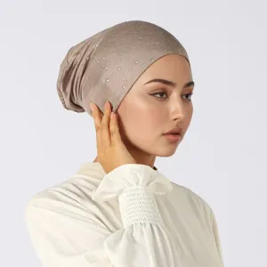 Elastische damesondermuts in licht taupe breisel met zilveren strasssteentjes, gedragen door een model