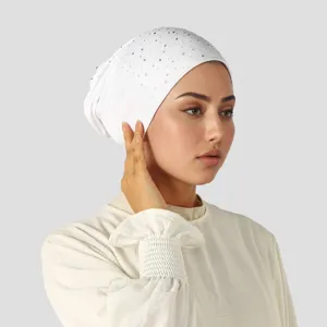 Witte elastische gebreide ondermuts met kleine strasssteentjes, gedragen in zijaanzicht