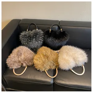 Five plush handbags in black, gray, brown, camel, and cream arranged on a black leather sofa