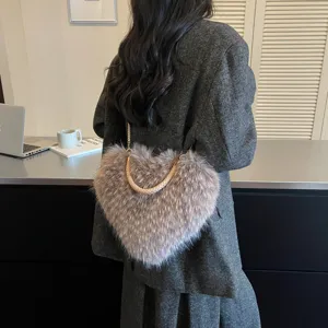 Back view of a person carrying a heart-shaped faux-fur bag with braided handle and gold chain strap