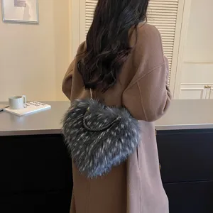 Rear view of a model carrying a gray faux-fur bag with chain strap and woven handle