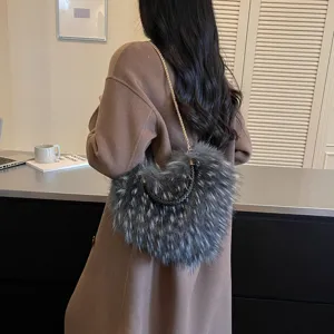 Back view of a woman carrying a shaggy gray bag with a black woven handle and gold chain strap