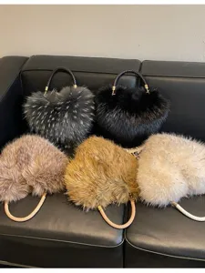 Five plush handbags in gray, black, brown, camel and ivory, arranged together with braided handles.