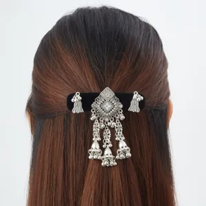 Rear view of dark hair secured with an ornate silver hair clip, rhinestones and dangling bell tassels