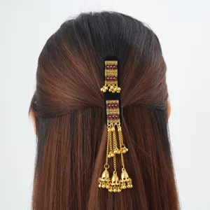Back view of styled hair with a black velvet clip, red stones and dangling gold bell tassels