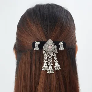 Rear view of dark hair with an antique silver clip, pink gem and dangling bell tassels
