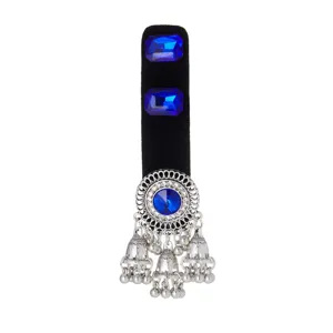 Silver filigree medallion with blue crystals and dangling bell tassels on a black velvet display