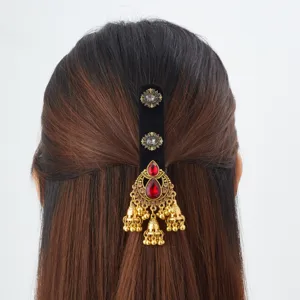 Vue de dos d'une coiffure mi-attachée avec barrette dorée, pierres rouges et pampilles à clochettes