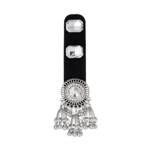 Close-up of a silver filigree ornament with a clear center stone and dangling bell charms