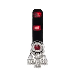Close-up of a black velvet base with red gems and ornate silver bell tassels hanging below