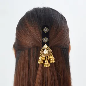 Vue arrière de cheveux foncés avec ornement en velours noir, cristaux et clochettes dorées