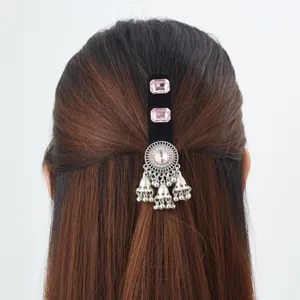 Back view of the hair accessory showing pink stones, a silver filigree medallion and dangling bell tassels