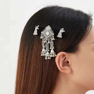 Side view of a model wearing a silver jeweled hair clip with dangling bells and tassel charms