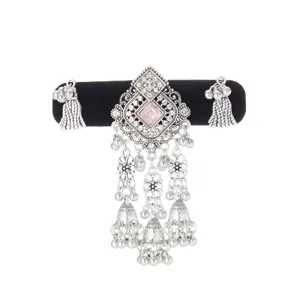 Ornate silver-tone openwork ornament with a pink center stone and dangling bell tassels