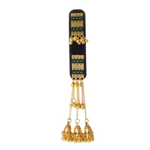 Detail of gold filigree, green stones, bead chains and bell pendants on black velvet backing
