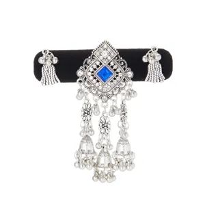 Close-up of the silver ornament's blue square gem, rhinestone accents and dangling bell tassels