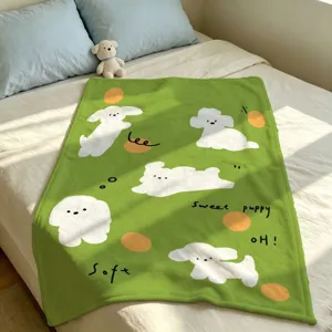 Groene zachte deken op een bed, met witte puppy's, oranje stippen en bedrukte woorden