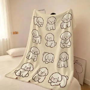 Couverture polaire crème drapée sur un lit, ornée de dessins réguliers de chiens mignons.