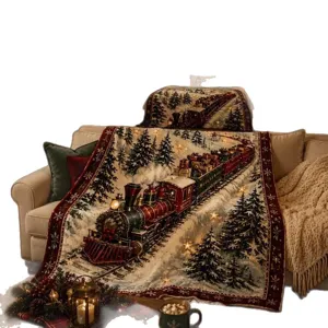 Vintage Christmas train throw blanket draped over a beige sofa, with snowy trees and red trim