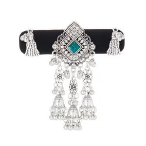 Detail of an antique-silver ornament with a green square gem, floral links, beads and bell tassels