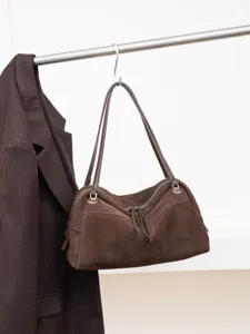Brown suede-textured bag hanging from a rail, with leather handles, zip closure and silver hardware