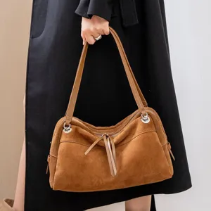 Women's brown suede leather Boston bag with long shoulder straps and metal ring details, hand-carried