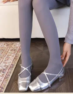 Close-up of gray-lilac ribbed tights paired with silver square-toe Mary Jane flats