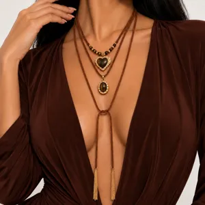 Gelaagde bruine koordketting met tijgeroog hart- en ovale hangers, gouden details en kwastjes