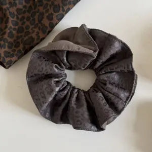 Primer plano de un coletero fruncido gris marrón con estampado de leopardo y elástico interior visible