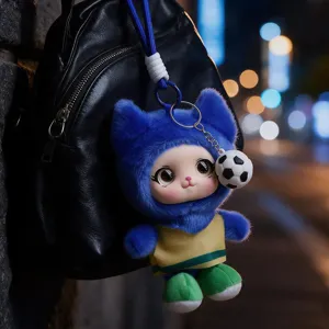 Blue plush cat-eared doll with a soccer ball charm hanging from a black backpack at night