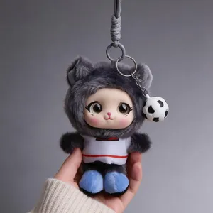 Close-up of a gray furry keychain character with red stripes, blue shoes and a soccer ball charm