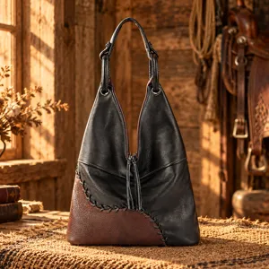 Sac cabas en cuir noir et brun, avec empiècements cousus main et pompon sur la fermeture