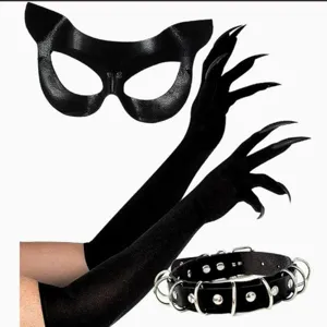 Vista plana de una máscara negra de gato, guantes largos con garras y collar con tachuelas metálicas