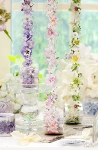 Three floral tape strips hang from clear stands beside rolls in soft natural window light