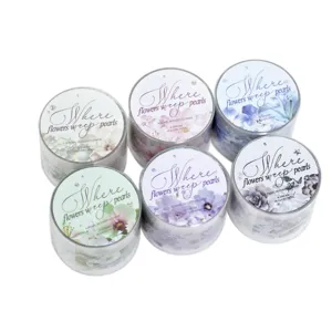 Six rolls of floral PET decorative tape in pastel colors, displayed in clear cylindrical cases