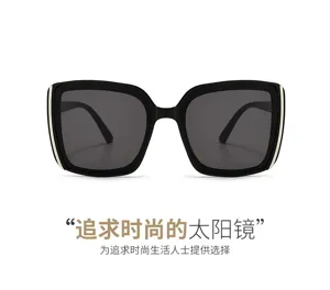 Front view of oversized black square sunglasses with dark gray lenses and slim gold temple accents