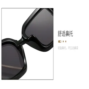 Close-up of the black sunglasses' nose bridge and nose pads beside dark gray gradient lenses