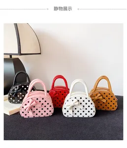 Five polka-dot mini handbags with bow details displayed together in black, pink, red, white and tan