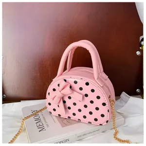 Close-up of a pink polka-dot bag with a sculpted bow, top handle and gold chain strap