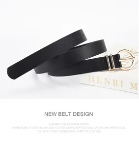 Ceinture noire à boucle ronde dorée et trous réglables, posée enroulée près d’un catalogue blanc