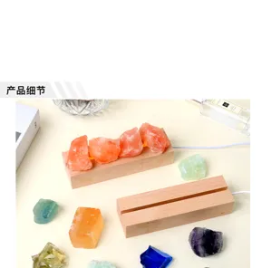Primer plano de cristales naranjas en bruto sobre una base de madera clara, con piedras de colores