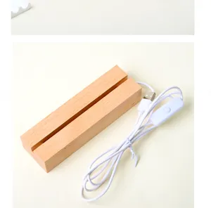 Detalle de una base de lámpara de madera clara con ranura, cable USB blanco e interruptor en línea