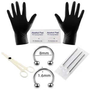 Vista plana de guantes negros, toallitas con alcohol, pinza, agujas y aros de herradura de 8 mm