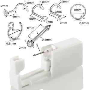 Set de piercing nasal con tachuelas y aros metálicos junto a un perforador blanco desechable