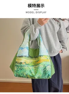 Model carrying a large shoulder bag with an oil-painted field landscape and contrasting green trim