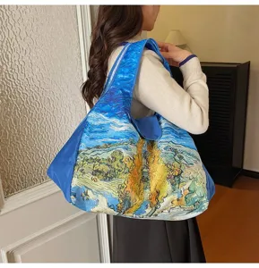 Woman carrying a roomy blue shoulder tote with vivid Van Gogh-style artwork indoors at home