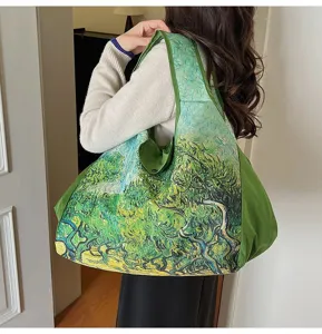 A woman carries a green tote with an impressionist olive tree print and a solid green side panel
