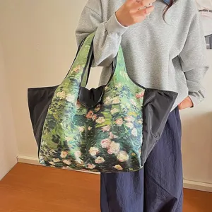 Large-capacity tote bag with green painterly rose print and black sides, shown on the shoulder